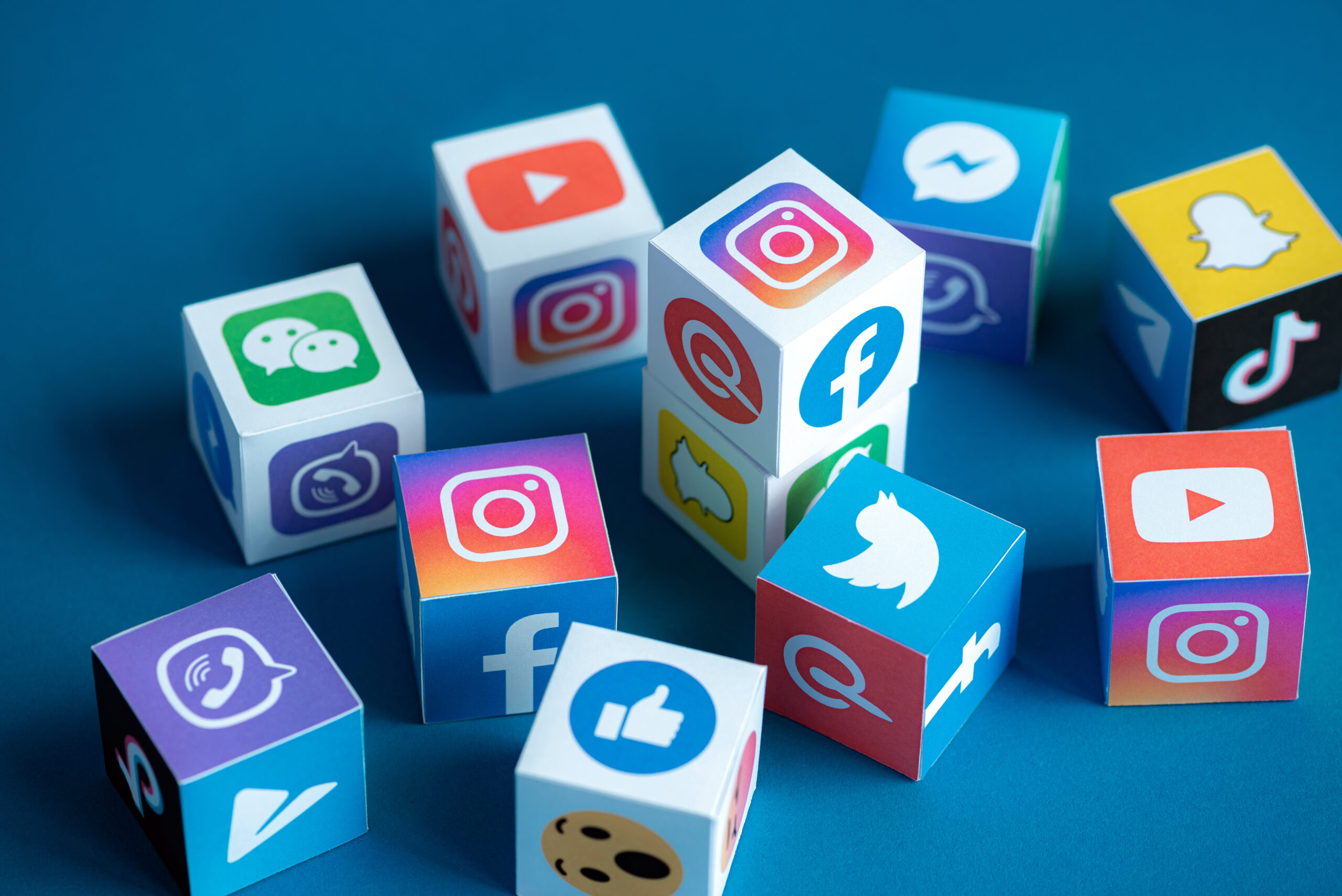 icons of popular social media apps appearing on a bunch of cubes, scattered on a table like dice