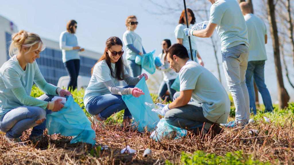 A group of happy non profit volunteers cleaning up some roadside litter